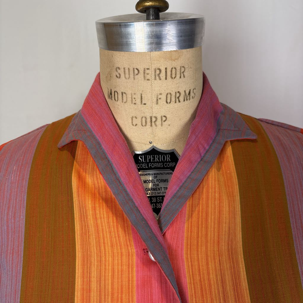 A striped button-up shirt in orange, pink, and yellow tones displayed on a vintage Superior Model Forms Corp. dress form mannequin against a plain light background.