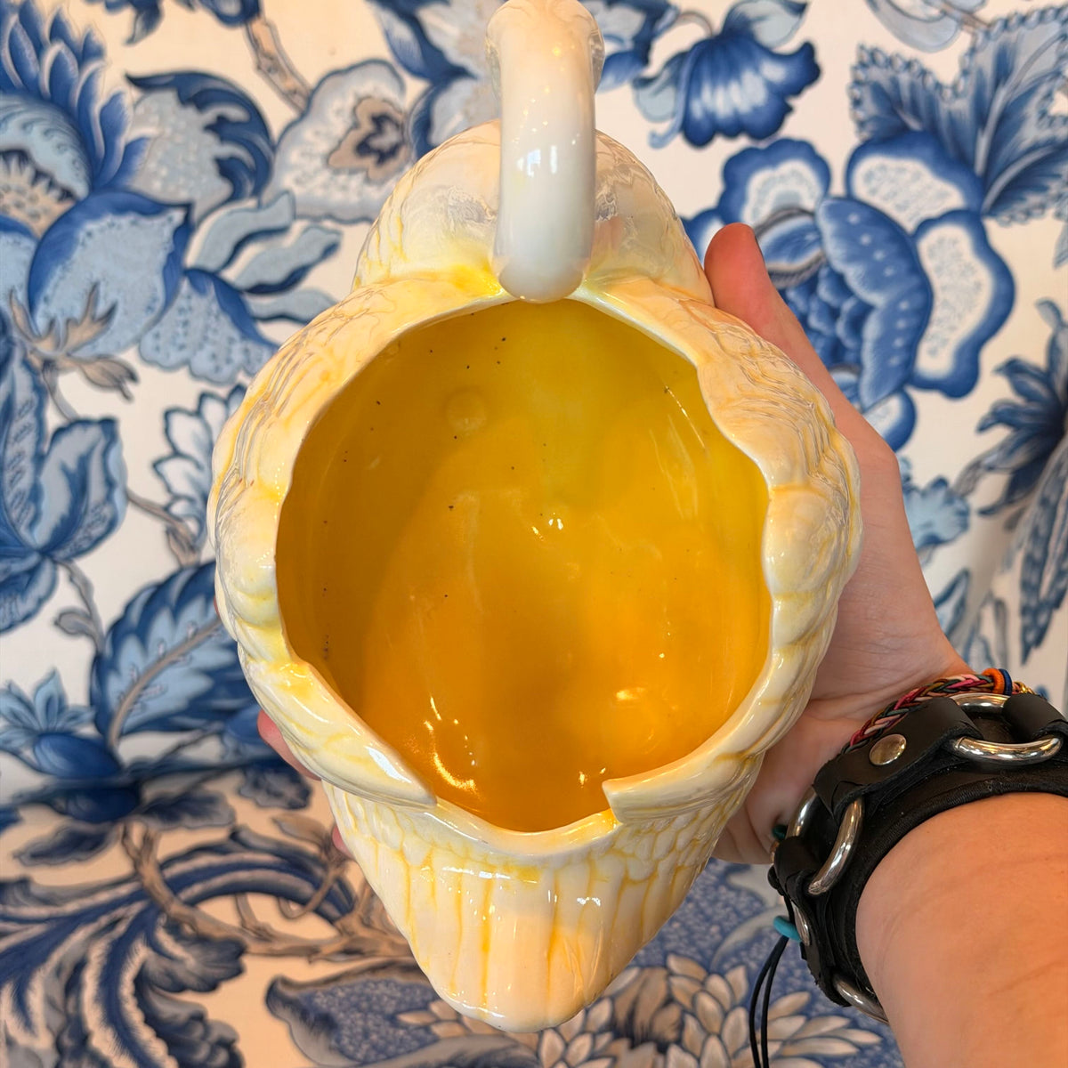 A yellow and cream-colored ceramic swan figure on a blue and white fabric surface.