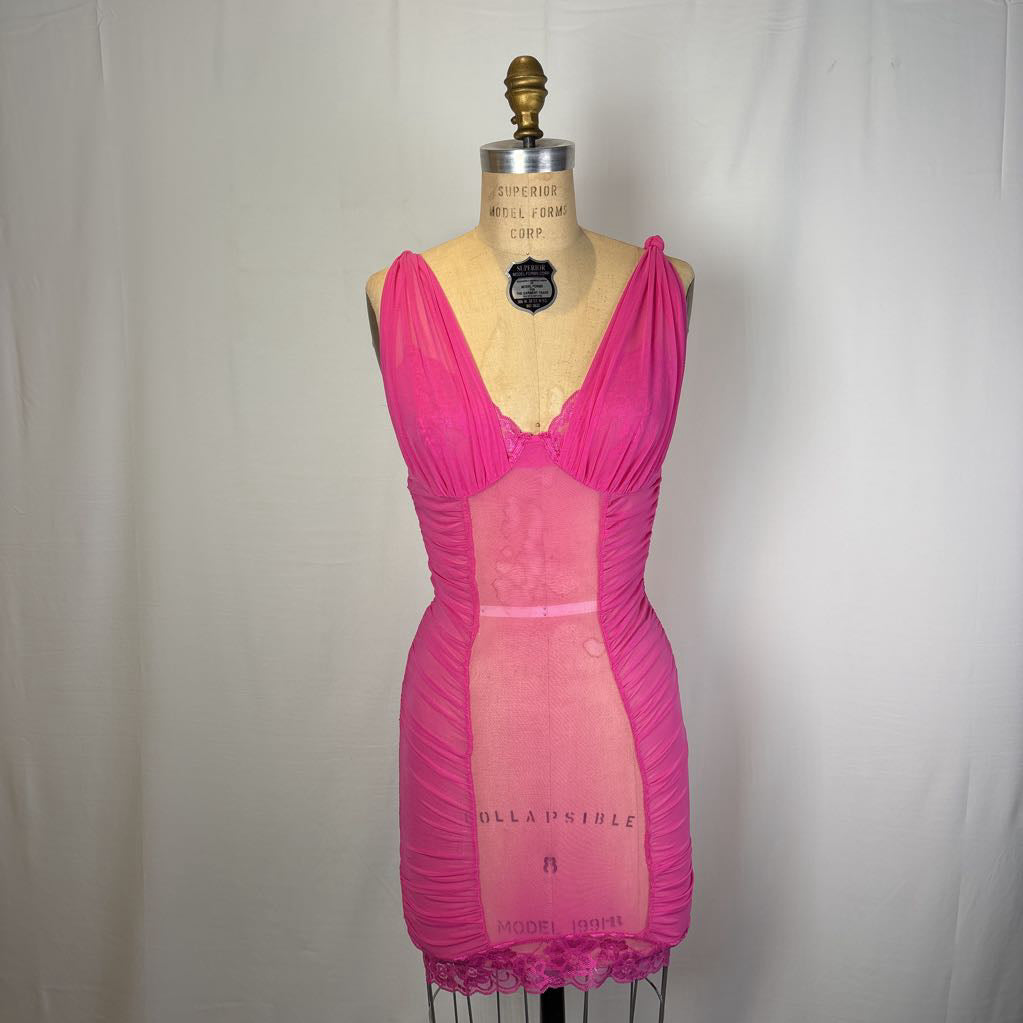A bright pink sheer lingerie chemise dress displayed on a vintage dress form mannequin against a white fabric backdrop.