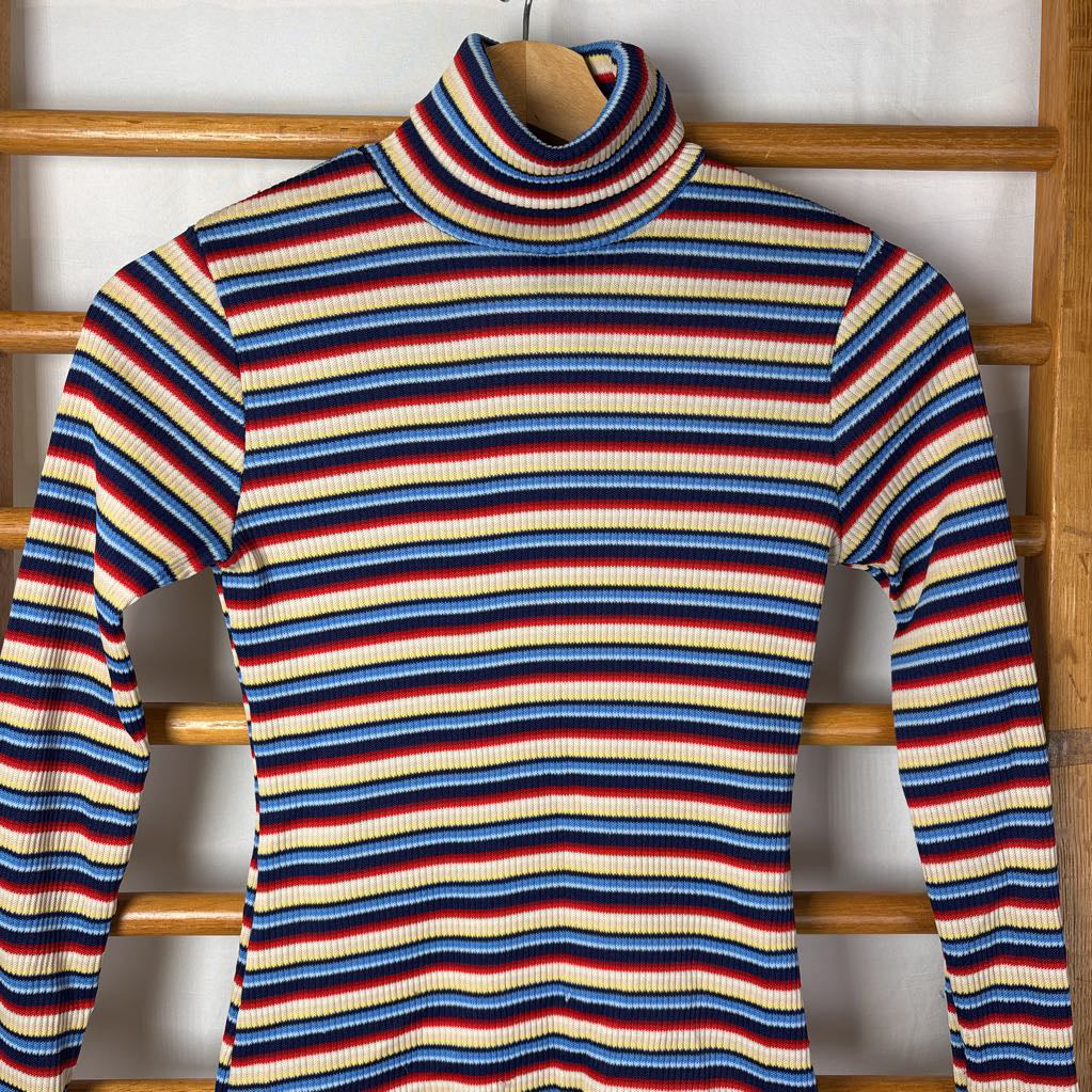 A vintage style striped turtleneck sweater on a wooden rack. 