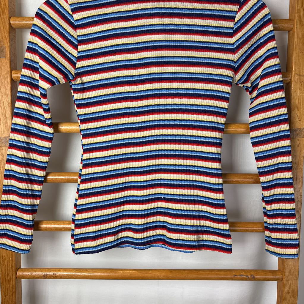 A vintage style striped turtleneck sweater on a wooden rack. 