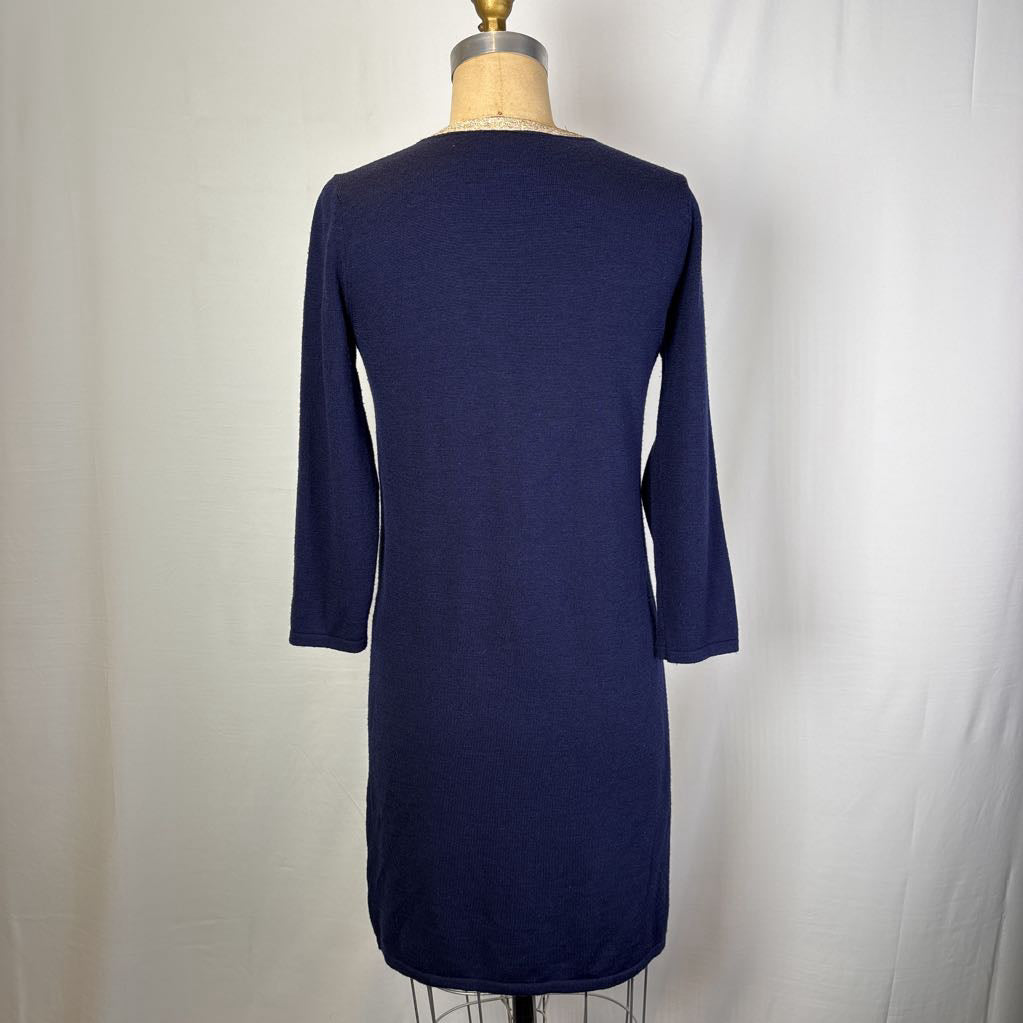 A navy blue knit dress displayed on a dress form mannequin, showing the back view with three-quarter sleeves against a white fabric backdrop.