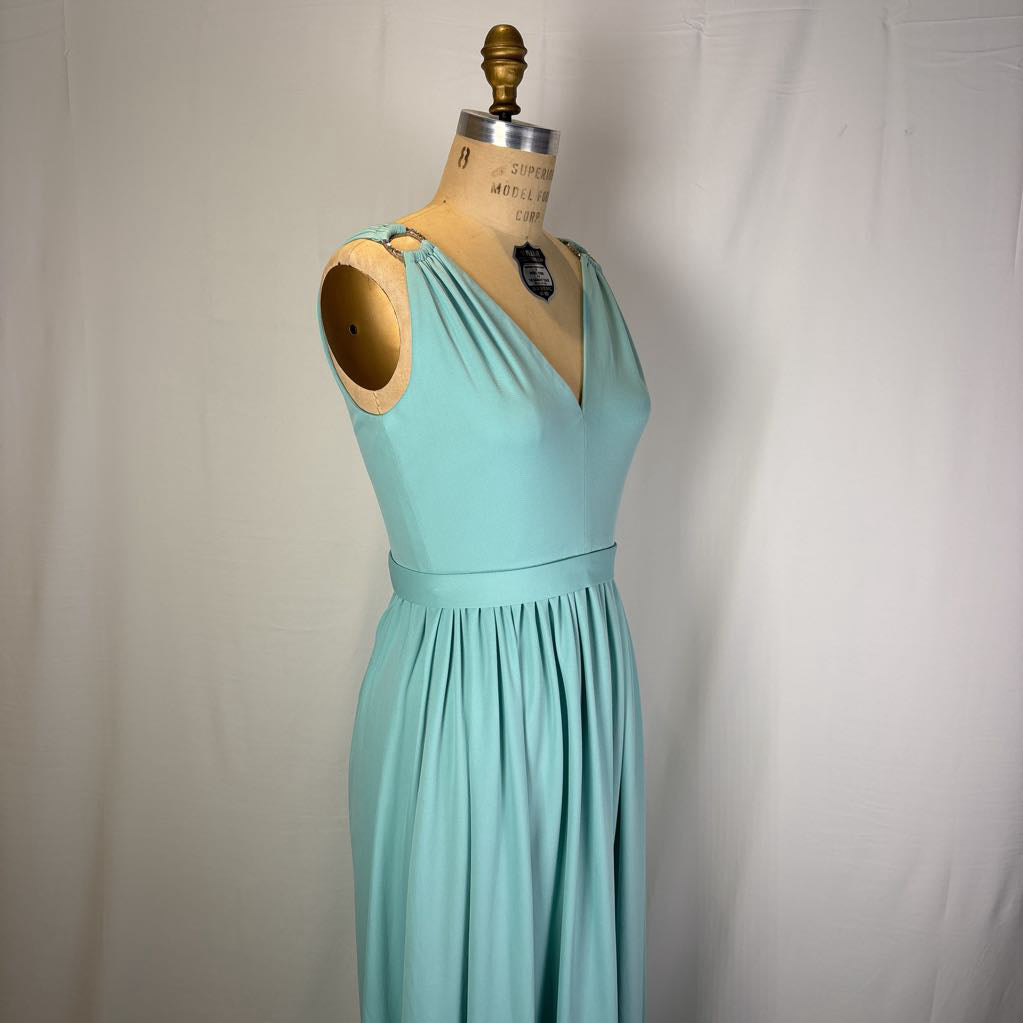 A light aqua blue sleeveless maxi dress displayed on a vintage wooden dress form mannequin against a white fabric backdrop.
