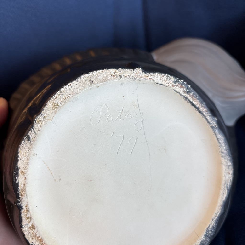 The bottom of a ceramic piece signed by Patsy '79.