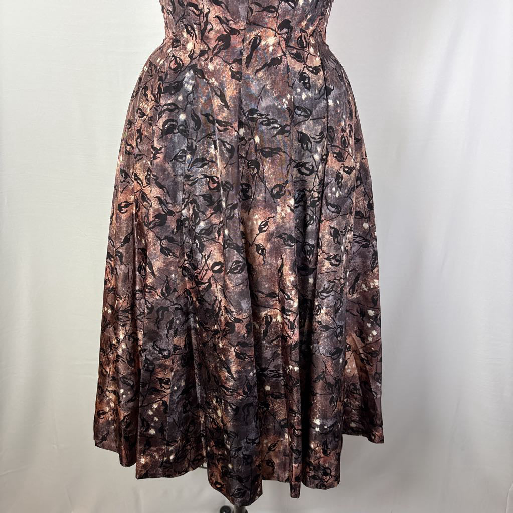 A vintage fit and flare A-line dress with an abstract pattern on a mannequin against a white wall.