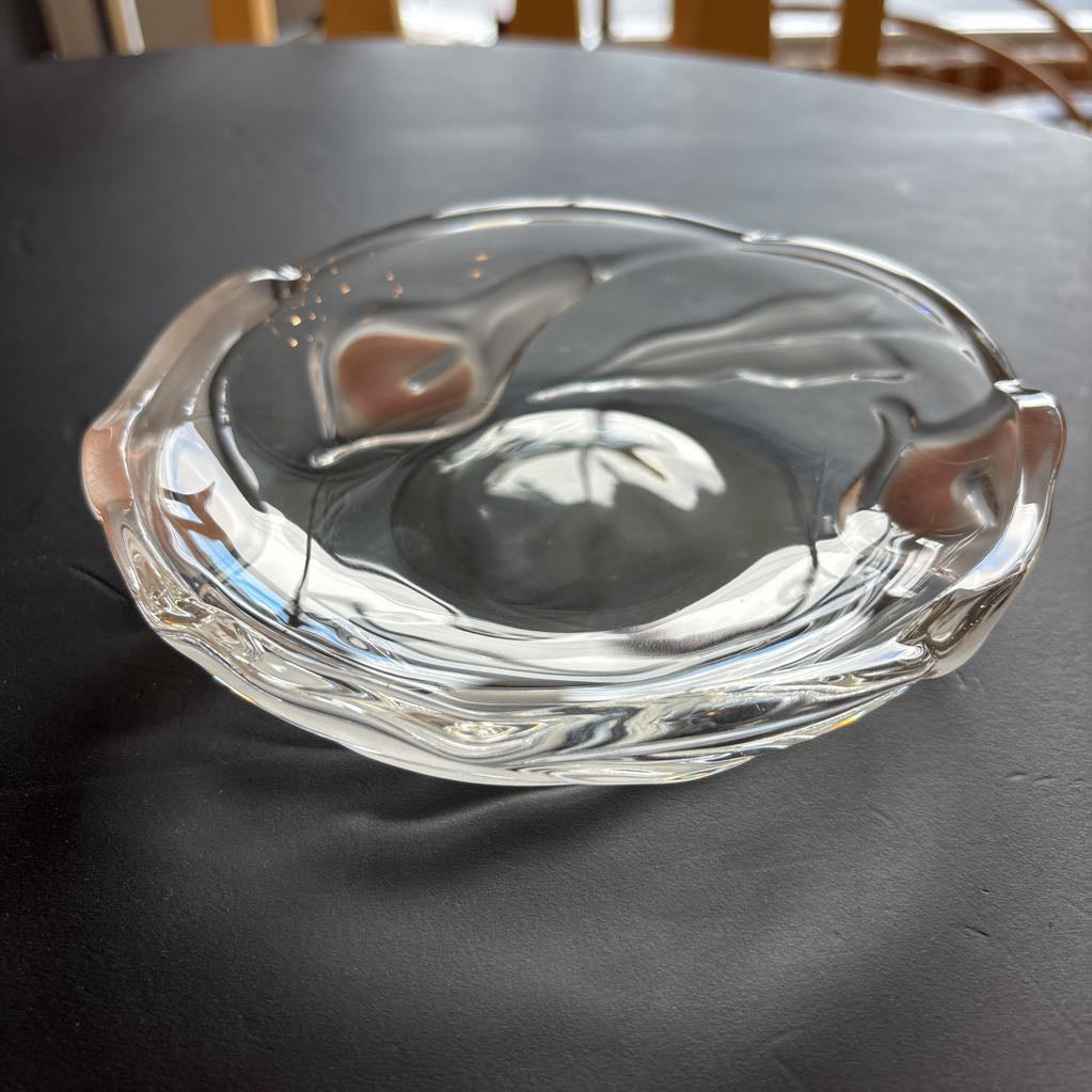 A glass plate with embossed frosted pink calla lilies sitting on a black table.