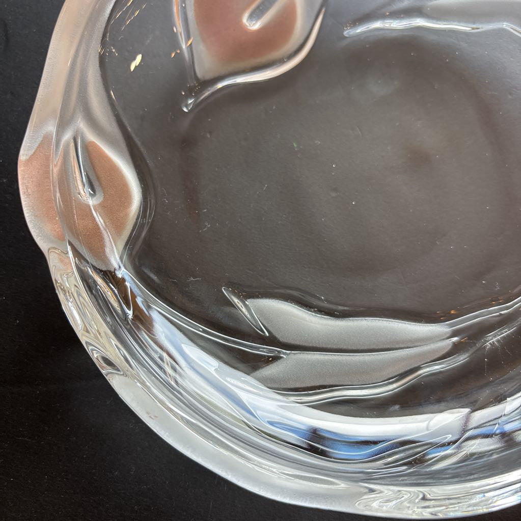 A glass plate with embossed frosted pink calla lilies sitting on a black table.