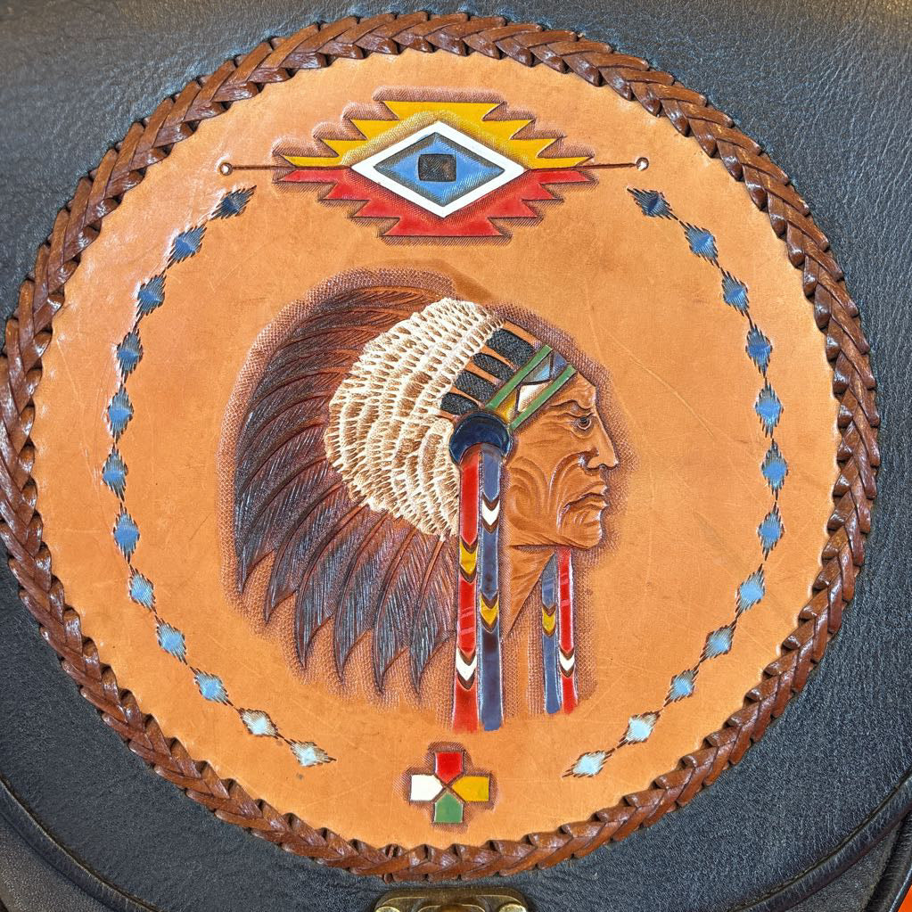 A black leather belt bag with a Native American figure's profile embossed in a circular design on the front. 