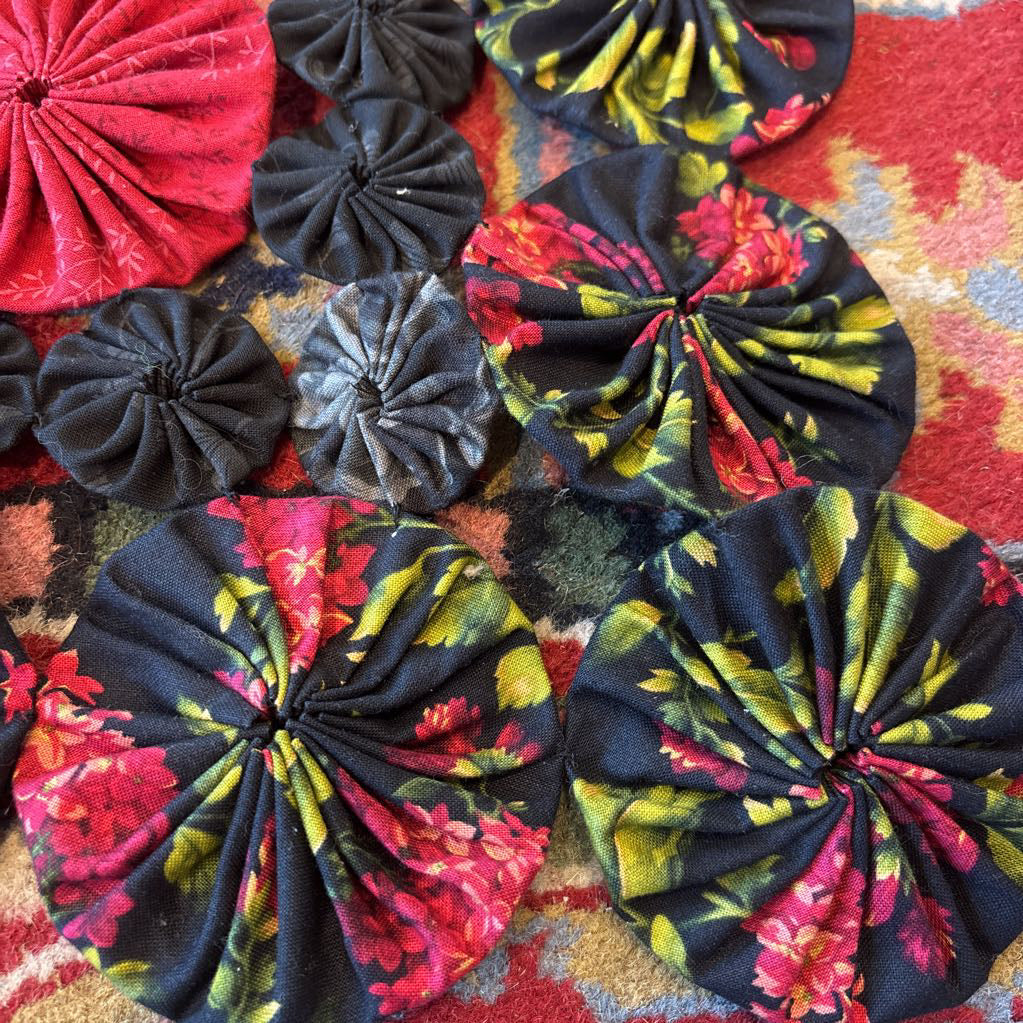 A red and black puff quilt on a red rug.