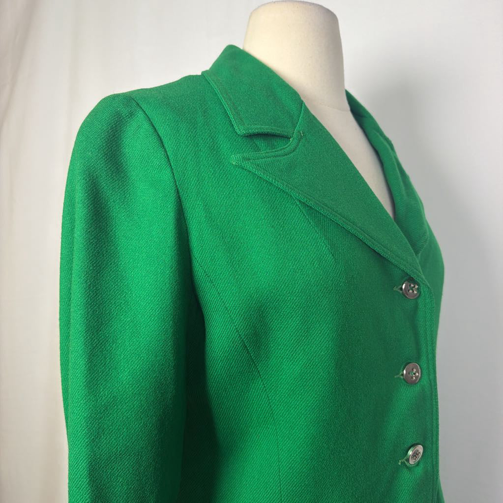 A bright green tailored jacket displayed on a cream mannequin torso against a light neutral background.