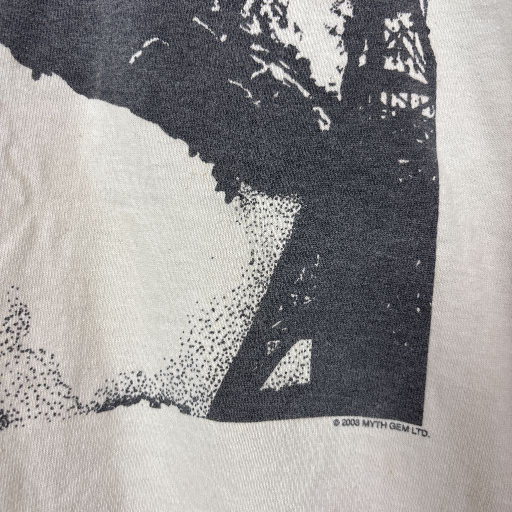 A white vintage style short sleeve t-shirt with an image of a Led Zeppelin album cover and the band's name in red letters. The shirt hangs on a wooden rack against a white background. 