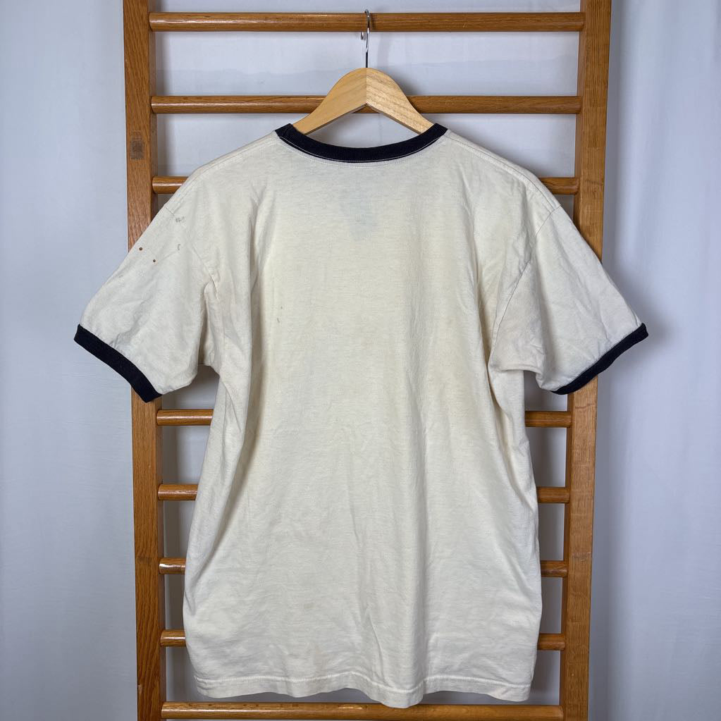 A white vintage style short sleeve t-shirt on a wooden rack against a white background. 