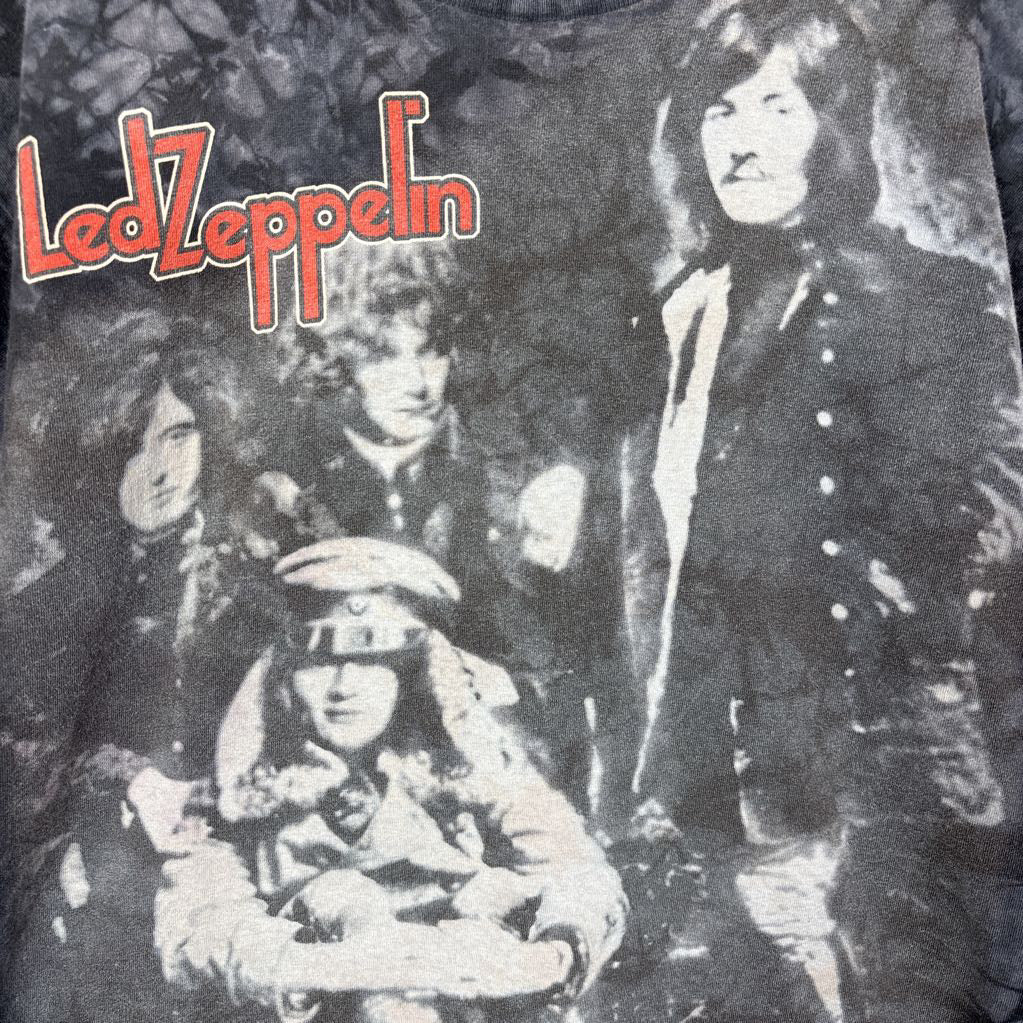 A dark gray tie-dye short sleeve t-shirt with an image of Led Zeppelin on it. The tee hangs on a wooden rack against a white background.