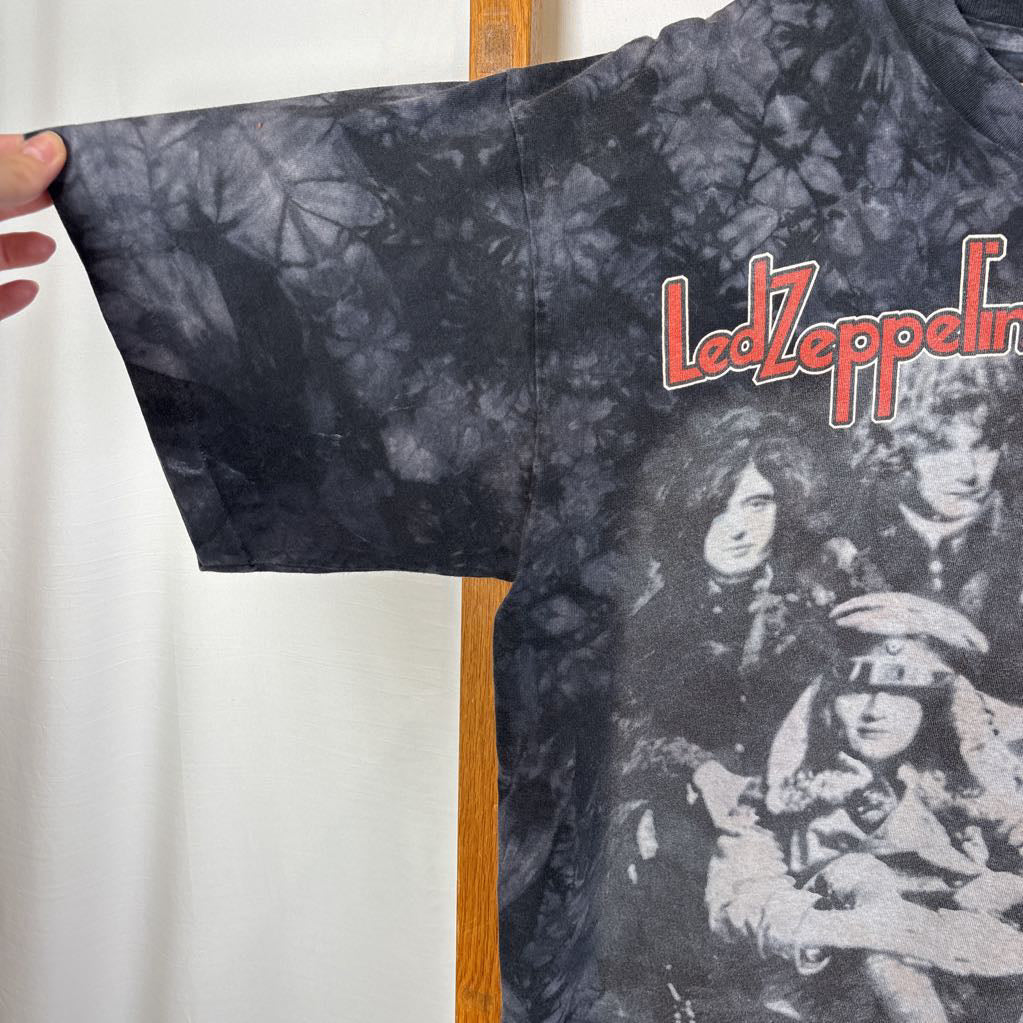 A dark gray tie-dye short sleeve t-shirt with an image of Led Zeppelin on it. The tee hangs on a wooden rack against a white background.
