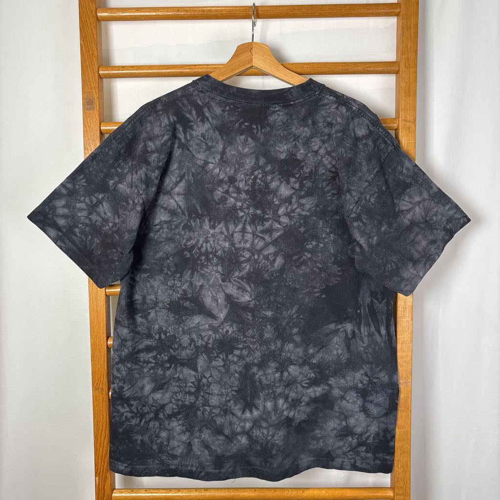 A dark gray tie-dye short sleeve t-shirt on a wooden rack against a white background.