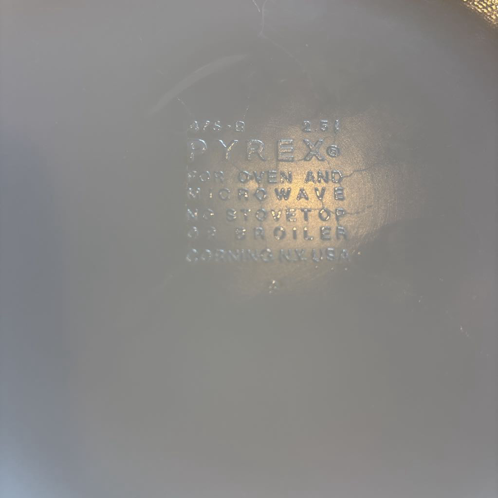 The bottom of a casserole dish on a wooden slat bench in a room setting. 