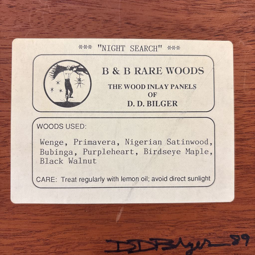 The back of an artwork with information about the artist and work as well as the signature and number of this creation. 