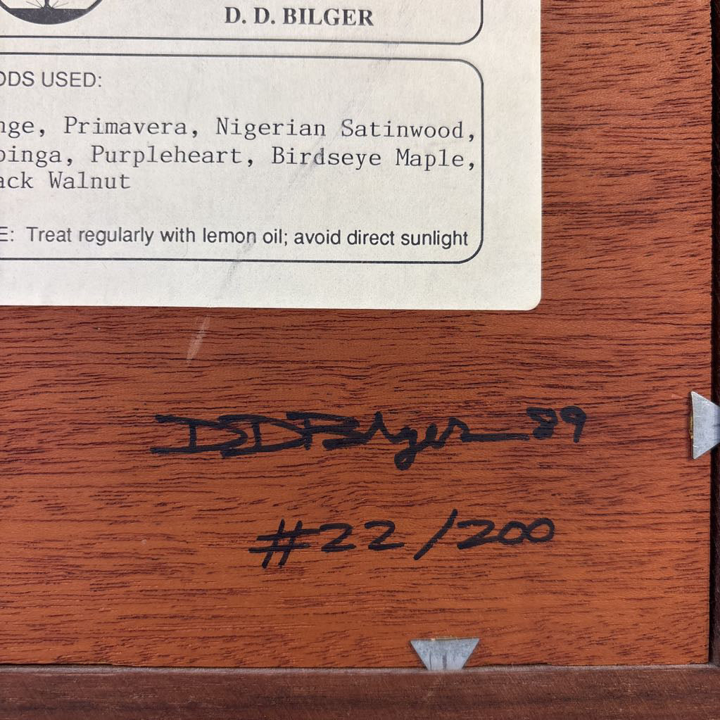 The back of an artwork with information about the artist and work as well as the signature and number of this creation. 