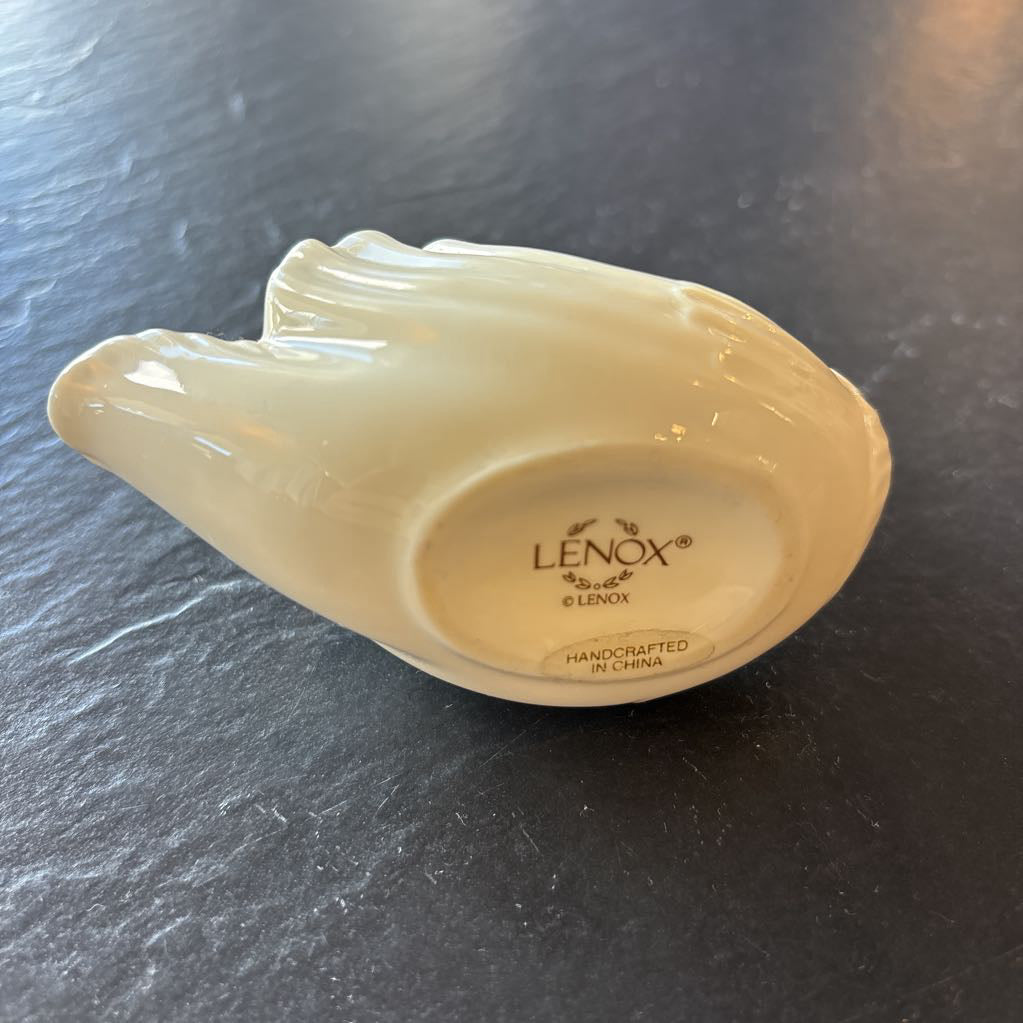 The bottom of a ceramic swan shaped object with branding reading "LENOX HANDCRAFTED IN CHINA."