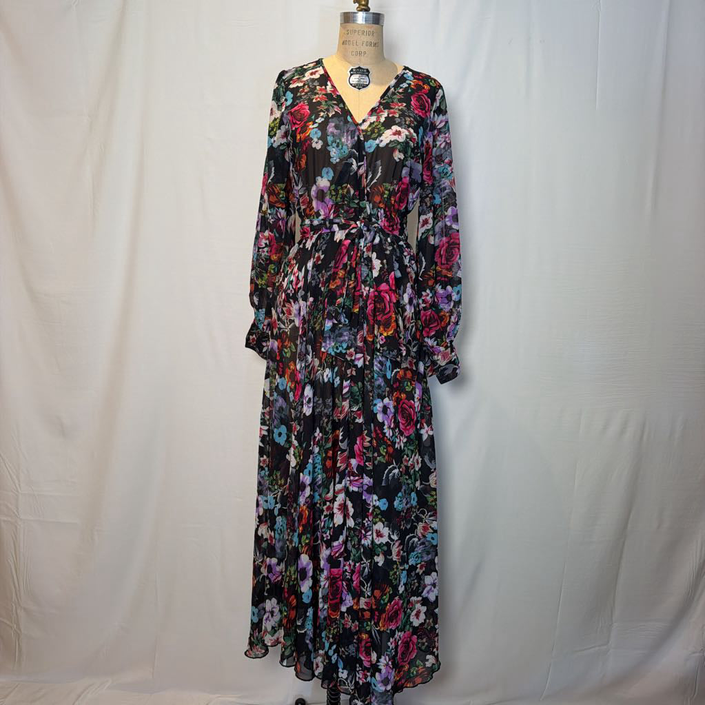 A floral maxi dress on a mannequin in front of a white wall. 