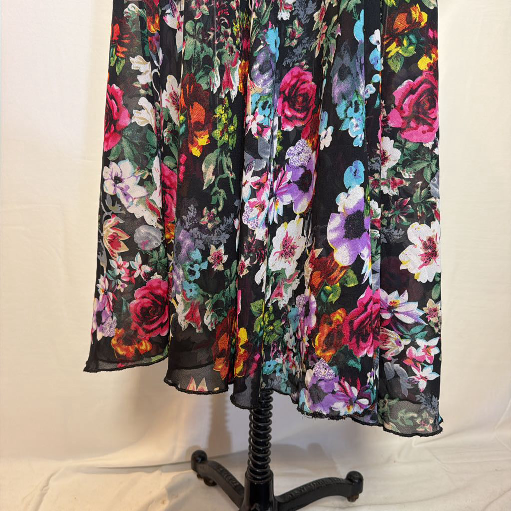A floral maxi dress on a mannequin in front of a white wall. 