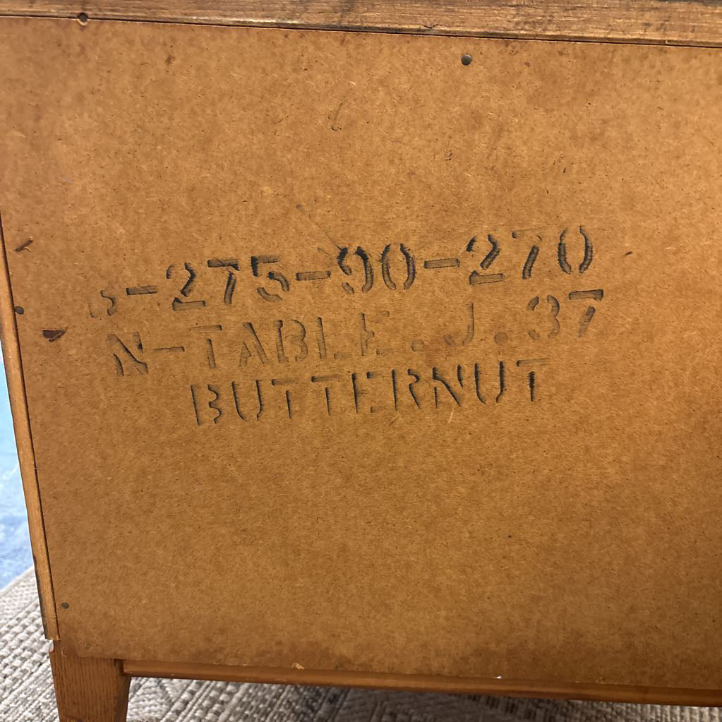 A wooden nightstand with drawers in a store setting. 
