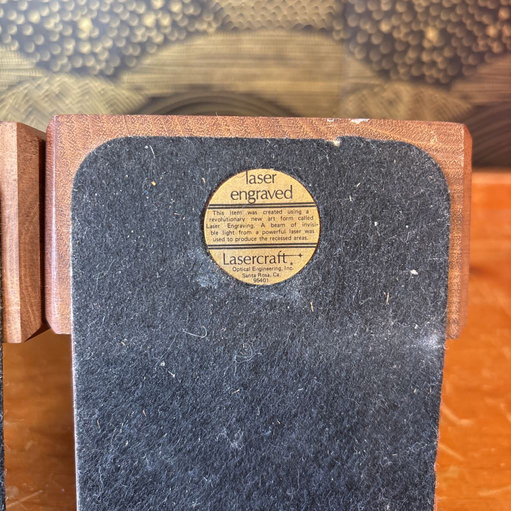 The bottom of a bookend with a sticker saying it was laser engraved.