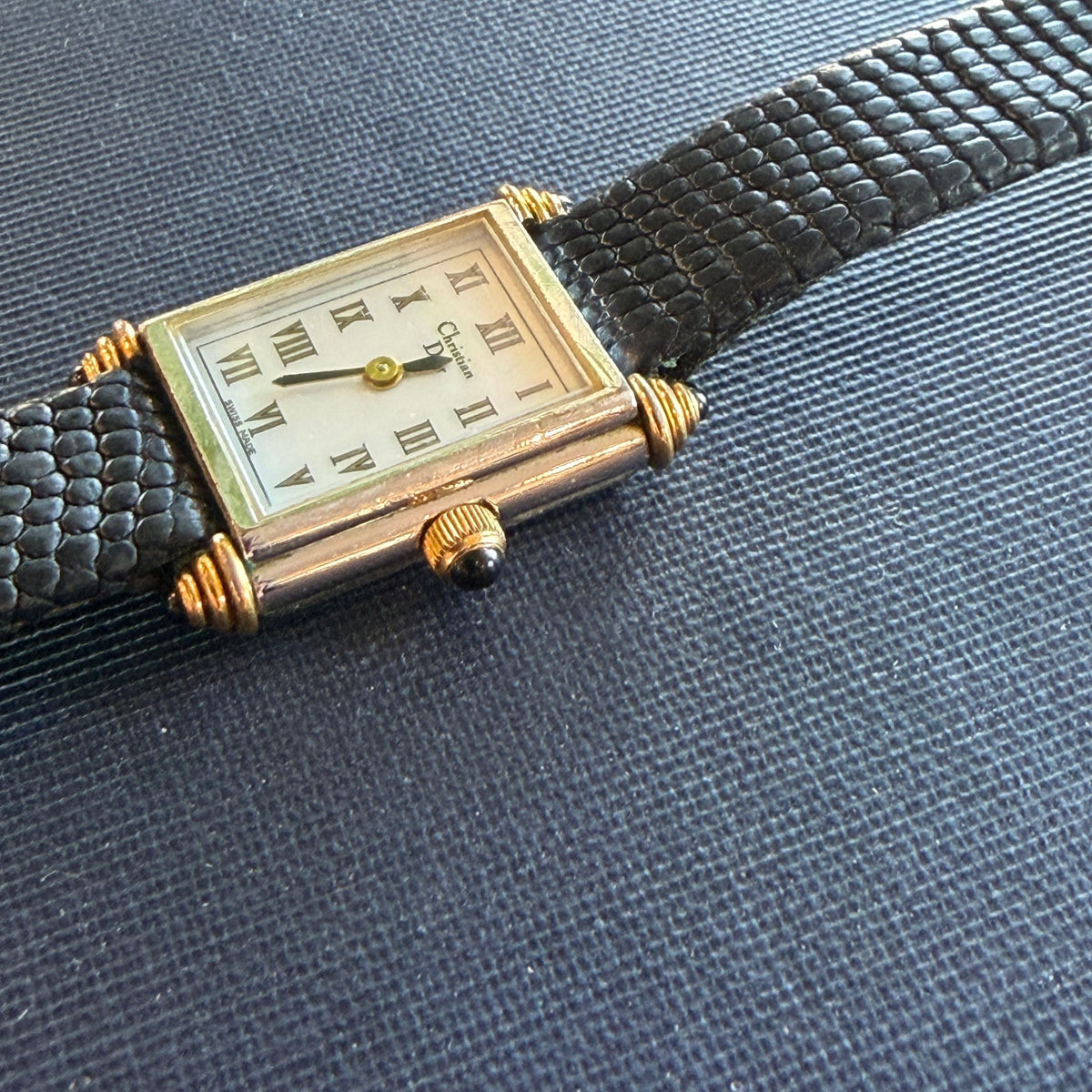 Showing the side of the Christian Dior tank watch with gold accents 