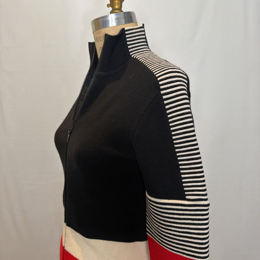 A black, red, and white color block zip-up jacket on a mannequin in front of a white wall.