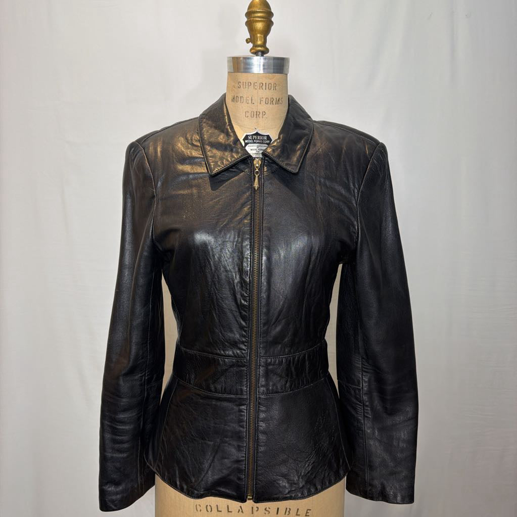 A black zip-up leather jacket on a mannequin in front of a white wall.