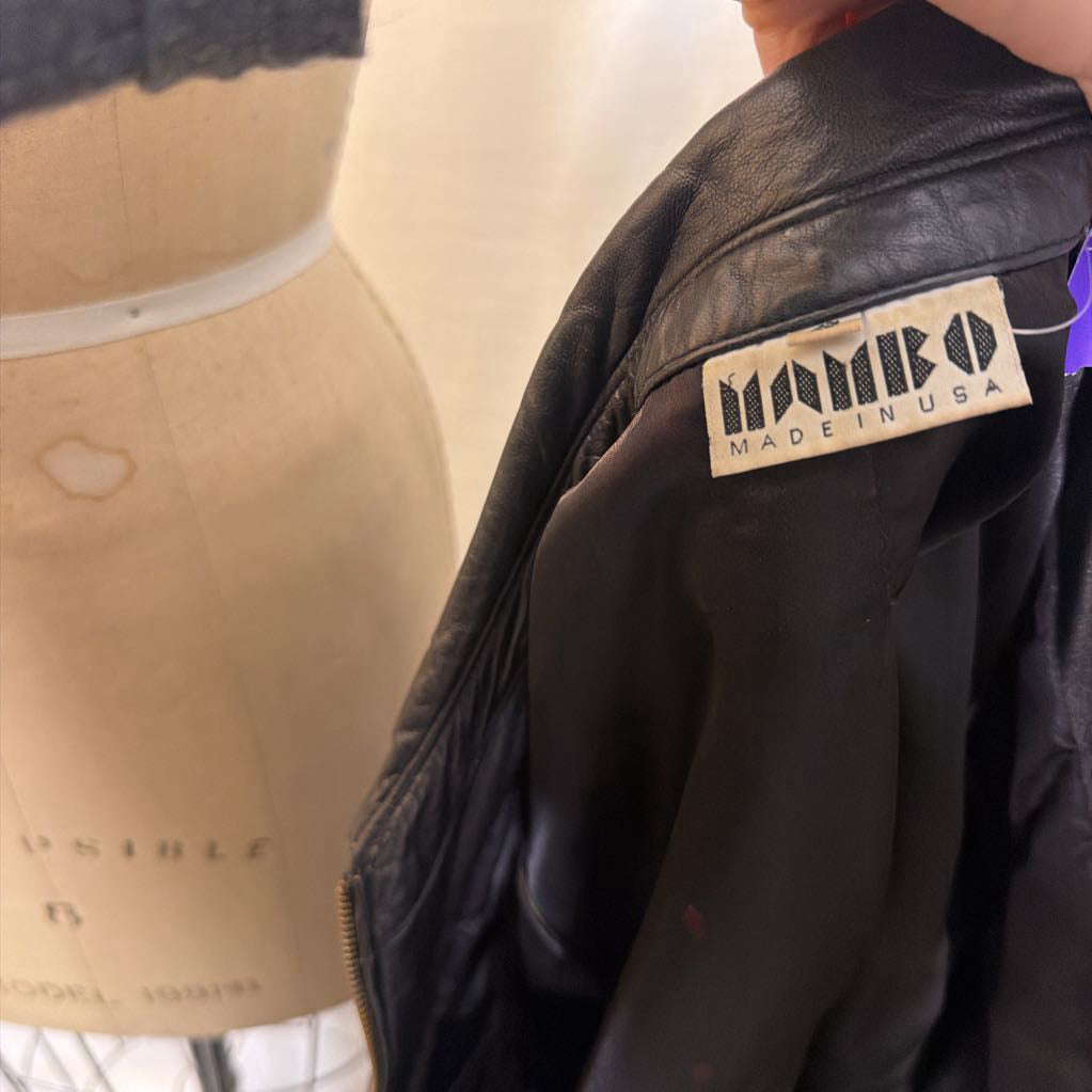 A "Mambo" brand tag on a black zip-up leather jacket 