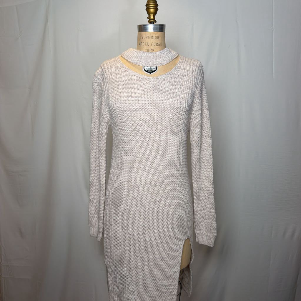 A white knit dress with an open neck and a slit on the bottom. It's on a mannequin in front of a white wall.