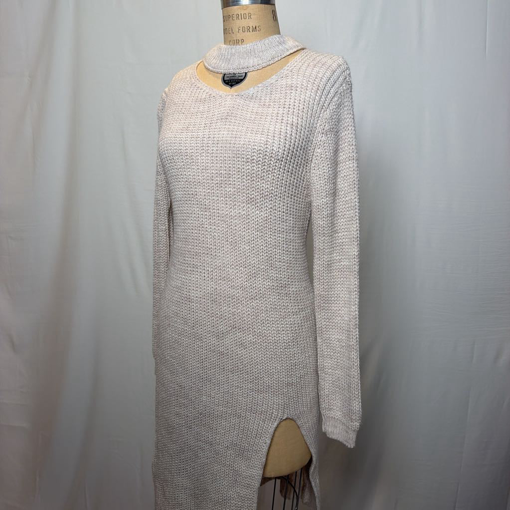 A white knit dress with an open neck and a slit on the bottom. It's on a mannequin in front of a white wall.