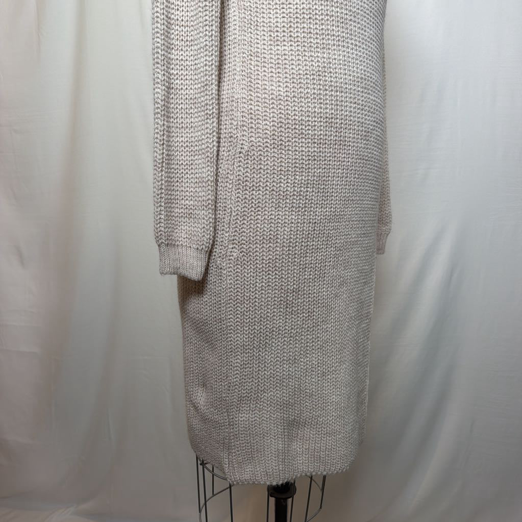 A white knit dress with an open neck and a slit on the bottom. It's on a mannequin in front of a white wall.