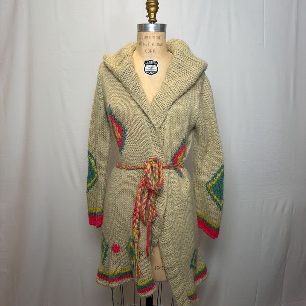 A tan belted knit sweater hoodie on a mannequin in front of a white wall.