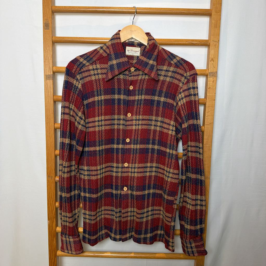 A button-up plaid shirt on a wooden rack. 