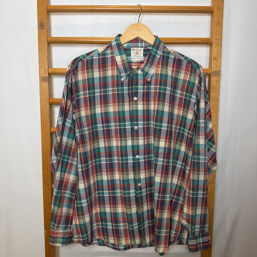 A plaid button-up shirt on a wooden rack. 