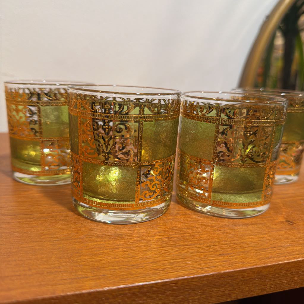 Four culver prado green glassware featuring a pale green tine and ornate 22k gold filigree checkerboard panels sitting on wood. 